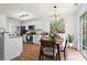 Bright eat-in kitchen features white cabinets, modern appliances, and a sunlit dining area with sliding glass doors at 585 Ashland Pkwy, Woodstock, GA 30189