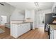 Bright kitchen with stainless steel appliances, granite countertops, white cabinets and hardwood floors at 585 Ashland Pkwy, Woodstock, GA 30189