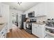Modern kitchen featuring stainless steel appliances, white cabinets, granite countertops and hardwood floors at 585 Ashland Pkwy, Woodstock, GA 30189