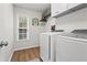 Functional laundry room with modern washer and dryer, storage shelves, and a window for natural light at 585 Ashland Pkwy, Woodstock, GA 30189