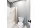 Small gray bathroom with a tiled shower-tub combo and a white toilet at 650 Garden Wilde Pl, Roswell, GA 30075