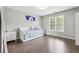 Bright bedroom features a hardwood floor, a daybed, and a window at 650 Garden Wilde Pl, Roswell, GA 30075