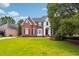 Charming brick home with a well-maintained lawn and classic architectural details at 650 Garden Wilde Pl, Roswell, GA 30075