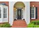 Charming front entrance with brick steps, a decorative door, and well-maintained landscaping at 650 Garden Wilde Pl, Roswell, GA 30075