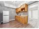 Bright kitchenette with wooden cabinets, white refrigerator, and a functional sink area at 650 Garden Wilde Pl, Roswell, GA 30075