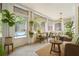 Cozy sunroom with wicker furniture, hanging plants, and views of the backyard pool at 650 Garden Wilde Pl, Roswell, GA 30075