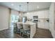 Open concept kitchen includes an island with seating, stainless appliances, and sliding door to patio at 2038 Brookhill Way Lot 6, Snellville, GA 30078