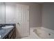 Bathroom with a tub and sink with cabinet space and a door to the toilet/shower area at 962 Taylors Farm Ct, Canton, GA 30115