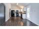 Modern kitchen with white cabinetry, black appliances, and wood-look flooring at 962 Taylors Farm Ct, Canton, GA 30115