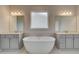 Bathroom featuring a soaking tub and dual vanities with elegant lighting at 316 Moab Ct, Stockbridge, GA 30281