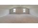 A spacious bonus room with two windows for natural light and plush carpeting at 316 Moab Ct, Stockbridge, GA 30281
