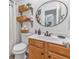 Bathroom vanity with a mirror and open shelving stocked with decorative baskets and everyday toiletries at 6317 Selborn Sw Dr, Atlanta, GA 30331