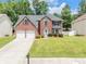 Charming two-story brick home featuring a well-manicured lawn, two-car garage, and classic architectural details at 6317 Selborn Sw Dr, Atlanta, GA 30331