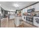 Bright kitchen with white cabinetry, stainless steel appliances, a center island, and wood-look flooring at 6317 Selborn Sw Dr, Atlanta, GA 30331