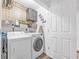 Laundry room with grey cabinets, geometric wallpaper, and front-loading washer and dryer at 6317 Selborn Sw Dr, Atlanta, GA 30331