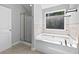 Bright bathroom with a separate shower and soaking tub beneath a window at 2565 Aaron Ct, Loganville, GA 30052