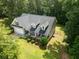 Aerial view of a charming home with a two-car garage, covered porch, and well-manicured lawn surrounded by trees at 2565 Aaron Ct, Loganville, GA 30052