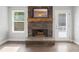 Close-up of stone fireplace, wooden mantel, hearth, with a painting above, and door to the outside at 2565 Aaron Ct, Loganville, GA 30052