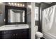 Well-lit bathroom with a dark vanity, framed mirror, and a shower-tub combination at 2645 Barkley Manor Dr, Lawrenceville, GA 30044