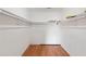 Walk-in closet with white walls, wood floors, and white shelves with hanging bars at 2645 Barkley Manor Dr, Lawrenceville, GA 30044
