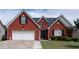 Charming red brick home with a well-manicured lawn and two-car garage in a suburban neighborhood at 2645 Barkley Manor Dr, Lawrenceville, GA 30044