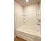 Clean bathroom featuring a large tub/shower combo with built-in shelving and wood-look flooring at 89 Cowpen Ct, Covington, GA 30014