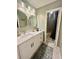 Bright bathroom features double mirrors, a large vanity, and a shower area with a shower curtain at 1044 Mariners Ct, Stone Mountain, GA 30083