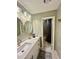 Bright bathroom features double mirrors, a large vanity, and a shower area with a shower curtain at 1044 Mariners Ct, Stone Mountain, GA 30083