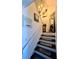 Stairway featuring carpeted steps, decorative wall art, and a modern lighting fixture at 1044 Mariners Ct, Stone Mountain, GA 30083