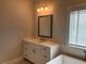 Bathroom featuring white vanity, grey framed mirror, and large window at 163 Basil St, Cumming, GA 30040