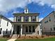 Charming two-story home featuring a brick facade, black shutters, and a welcoming front porch at 163 Basil St, Cumming, GA 30040