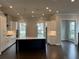 Modern kitchen featuring white cabinetry, stainless steel appliances, an island, and dark hardwood floors at 163 Basil St, Cumming, GA 30040