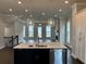 Modern kitchen features a large island, stainless steel appliances, and stylish pendant lighting at 163 Basil St, Cumming, GA 30040
