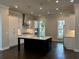 Modern kitchen featuring white cabinetry, stainless steel appliances, an island, and dark hardwood floors at 163 Basil St, Cumming, GA 30040