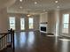 Living room with fireplace, hardwood floors, and plenty of natural light from large windows at 163 Basil St, Cumming, GA 30040