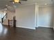 Neutral living room with dark hardwood floors, staircase, and bright light at 163 Basil St, Cumming, GA 30040