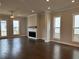Cozy living room with hardwood floors, fireplace, and ample natural light from surrounding windows at 163 Basil St, Cumming, GA 30040