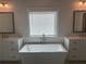 Bright main bathroom features soaking tub, dual vanities, and modern fixtures at 163 Basil St, Cumming, GA 30040