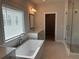 Spacious main bathroom showcasing soaking tub, glass shower, and modern design at 163 Basil St, Cumming, GA 30040
