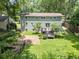 Backyard view of the two-story home featuring a deck, stone patio, privacy fence and beautifully landscaped yard at 2259 Eastway Rd, Decatur, GA 30033