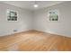 Bright bedroom with hardwood floors, white walls, two windows, and a modern ceiling fan at 2259 Eastway Rd, Decatur, GA 30033