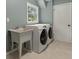 Functional laundry room with modern washer and dryer, utility sink, and a window for natural light at 2259 Eastway Rd, Decatur, GA 30033