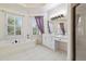 Bright bathroom with a soaking tub, double vanity, and window with modern finishes and tile flooring at 3450 Merganser Ln, Alpharetta, GA 30022