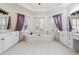 Luxurious bathroom features a soaking tub surrounded by windows, elegant curtains, and dual vanities at 3450 Merganser Ln, Alpharetta, GA 30022