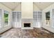Bright living room featuring a fireplace with built-in shelving, large windows, and luxury tile flooring at 3450 Merganser Ln, Alpharetta, GA 30022