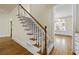 Welcoming staircase with wood and white accents and views into the dining room at 3450 Merganser Ln, Alpharetta, GA 30022