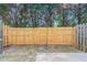 Backyard with a tall wooden fence, concrete patio, and mature trees at 4217 High Park Ln, Atlanta, GA 30344