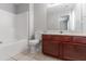 Bathroom with tiled floor, cherry cabinet, white toilet and tub with shower at 4217 High Park Ln, Atlanta, GA 30344
