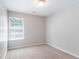 A bright bedroom featuring neutral walls, plush carpeting, and a large window offering natural light at 4217 High Park Ln, Atlanta, GA 30344