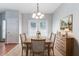 Dining area featuring a rustic wood table, chandelier, and French doors to backyard at 4217 High Park Ln, Atlanta, GA 30344